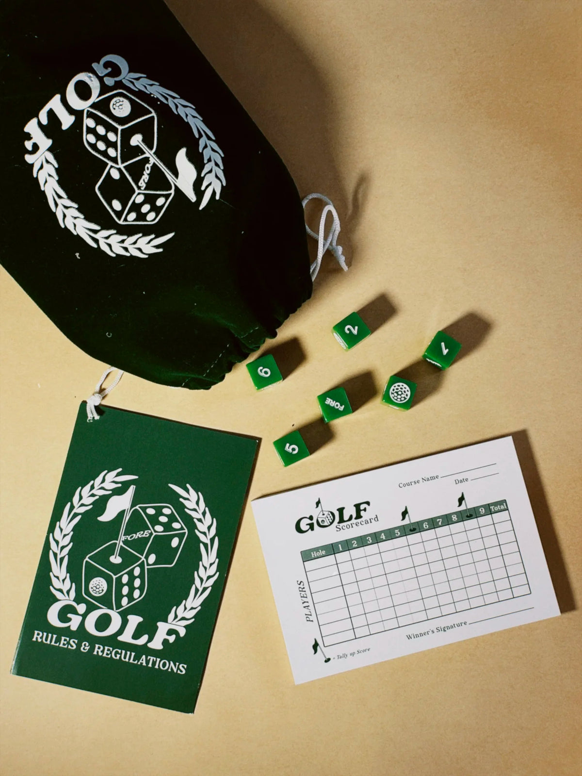 Golf-themed dice set with dice, rules book, and scorecard on a beige surface.

